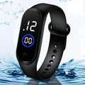 Black smartwatch with digital display on a water-themed background