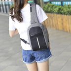 Person wearing a gray and black backpack outdoors on a paved path.